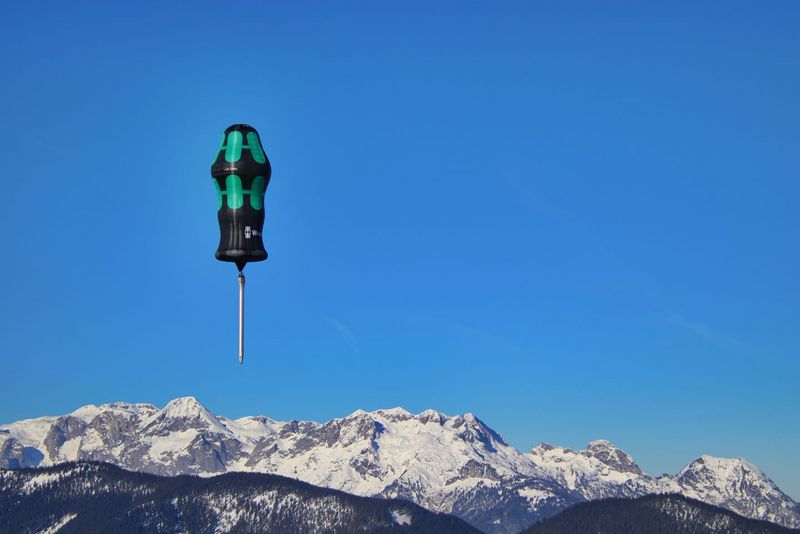 Heißluftballon in Form eines Wera Schraubendrehers vor schneebedeckten Bergen und blauem Himmel