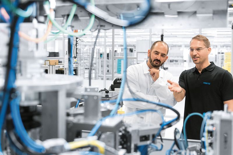 Symbolbild zwei Mitarbeiter vom deutschen Automatisierungstechnik-Experte in Arbeitsumfeld