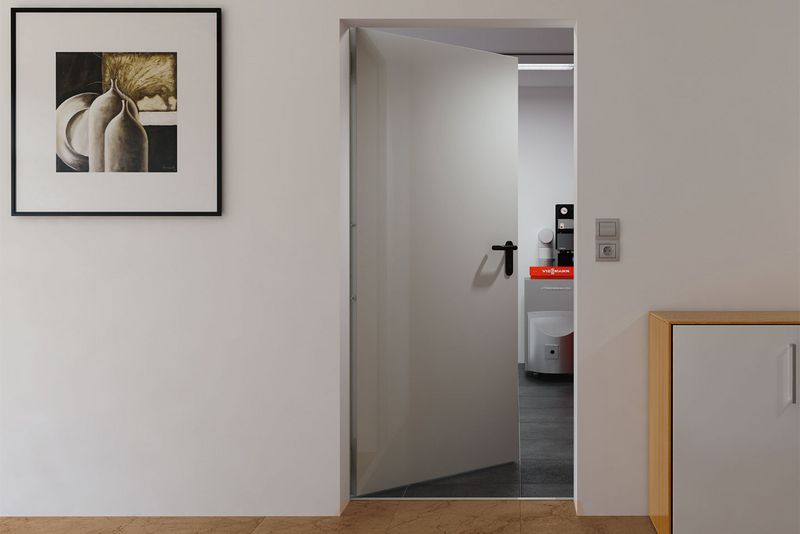 graue Wand mit geöffneter grauer Tür, Bild an Wand und Kasten